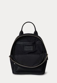 Melnas neilona mugursomas ar izliekto augšu, divām siksnām un priekšējo rāvējslēdzēja kabatu. Iezīmējas ar zeltītām rāvējslēdzēja aparatūrām un auduma iekšpusi.