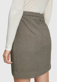 Grå rutig kjol med skräddarsydd passform, med midjeband, bakficka och mjuk textur. Synlig sömdetalj längs sömmarna.