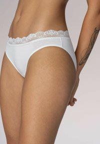 Mutande bianche di cotone con un bordo in pizzo in vita, caratterizzate da una texture liscia e un design a gamba alta per il massimo comfort.