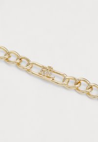 Gullkjede armb�ånd med sammenkoblede lenker og et rektangulært akcent med initialene "RL" gravert. Høyglanset metallisk finish.