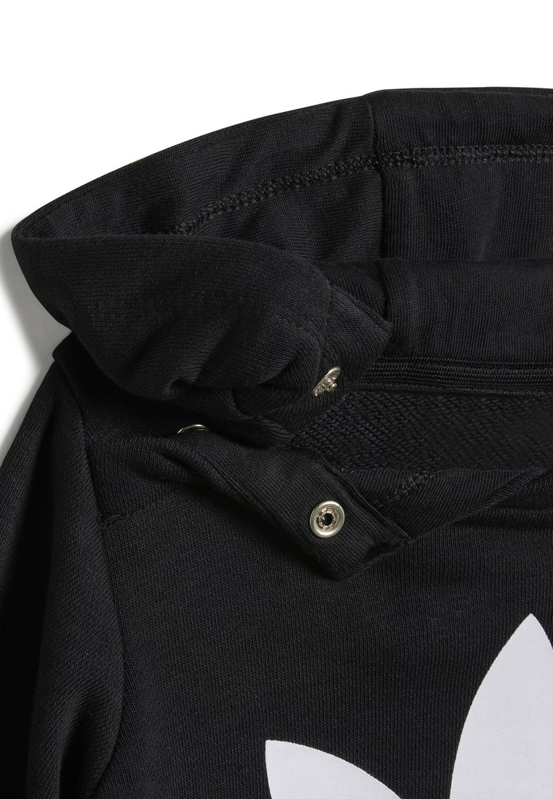 Felpa nera con una trama intrecciata, presenta un cappuccio pieghevole, chiusura a pressione e un grande logo bianco in evidenza sul davanti.