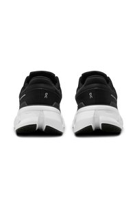 Schwarze Sportschuhe mit einer strukturierten oberen Schicht, kontrastierender weißer Zwischensohle und einzigartigem Fersendesign, das Branding an den Seiten aufweist.