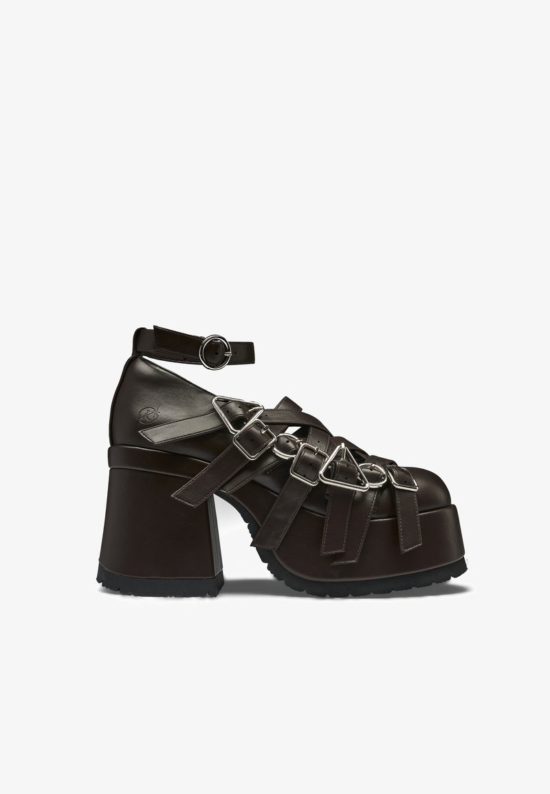 Stevige donkerbruine plateauhak met meerdere gespsluitingen en een enkelriem met een ronde metalen gesp.