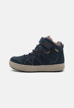 Navy suede high-top shoe with a textured rubber sole, fleece lining, adjustable velcro strap, and contrasting brown stitching accents.
