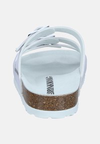 Sandale blanche avec une semelle en liège, des brides texturées douces et un design minimaliste avec des découpes. Logo visible sur la semelle intérieure.