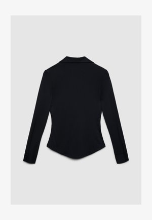 Chemise noire à manches longues avec col cranté, tissu lisse, coupe ajustée et poignets à boutons. Ourlet droit à l'arrière.