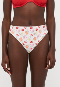 Calções de bikini com uma base branca, apresentando padrões coloridos de frutas e flores. O tecido tem uma textura suave e um corte elegante.