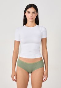 Biała bluzka z krótkim rękawem i oliwkowe, prążkowane majtki. Bluzka ma dopasowany krój, a majtki mają gładki pas.