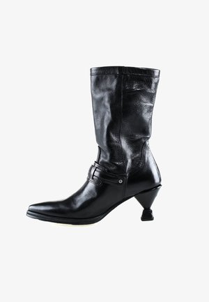 Botte en cuir noir mi-mollet avec bout pointu, bride décorative et boucle, et un talon unique incliné en forme de cône.