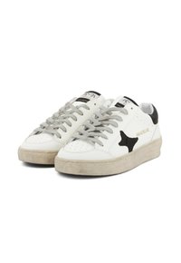 Sneakers bianchi a basso profilo con lacci grigi, dettaglio a stella nera sui lati, inserto sul tallone nero e suole beige leggermente usurate.