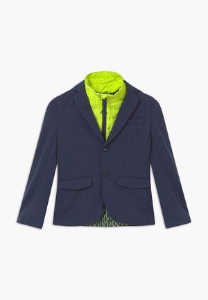 Granatowa marynarka z dwiema kieszeniami z przodu, zapięciem na jeden guzik oraz jasnoniebieską pikowaną podszewką z geometrycznym wzorem.