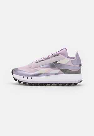 Chaussures de sport violet clair au design élégant, avec des accents réfléchissants, une tige texturée et une semelle extérieure en caoutchouc noire équipée de pointes.