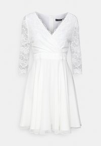 Weißes Kleid mit langen Spitzärmeln, V-Ausschnitt und tailliertem Oberteil. Der fließende Rock endet oberhalb des Knies und hat einen Reißverschluss auf der Rückseite.