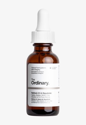 Amber glass dråpeflaske med hvit hette. Inneholder Retinol 1% i Squalane. Etiketten har tekst i svart og grått på en hvit bakgrunn.