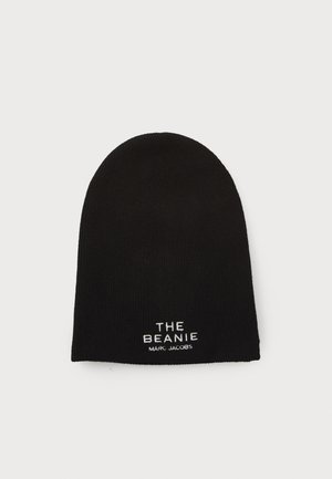 Black knit beanie with a rounded top, featuring white embroidered text: "THE BEANIE" and "MARC JACOBS" near the hem.