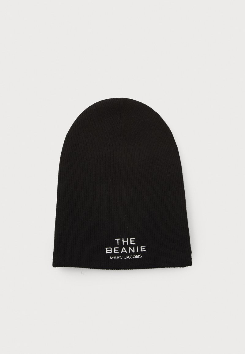 Black knit beanie with a rounded top, featuring white embroidered text: "THE BEANIE" and "MARC JACOBS" near the hem.