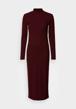 Burgundi ribbattu neulottu mekko, jossa on korkea kaulus ja pitkät hihat, ja joka tuo esiin vartalon muotoja sekä on nilkkoihin saakka ulottuva.