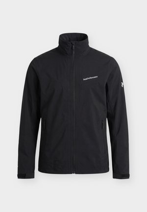 Veste noire zippée intégrale avec col montant, poches latérales zippées, poignets ajustables et logo "Peak Performance" sur la poitrine et la manche gauche.