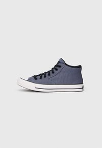 Sapatilhas altas, feitas de lona azul, com detalhes em preto, fecho de atacadores, biqueira de borracha branca e sola listrada em branco e preto.
