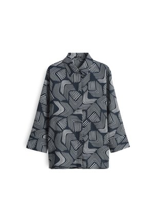 Chemise marine avec des motifs géométriques ondulés blancs, design avec col et manches trois-quarts. Fabriquée en tissu lisse avec une texture légère.