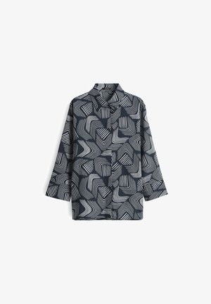 Camicia blu marino con motivi geometrici bianchi ondulati, design con colletto e maniche a tre quarti. Realizzata in tessuto morbido con leggera texture.