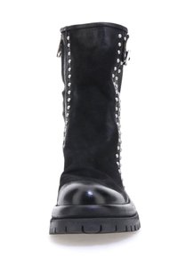 Crne kožne čizme s srebrnim zakovicama na strani, debelim crnim đonom i zaobljenim vrhom. Detalj sa zatvaračem bliže vrhu.