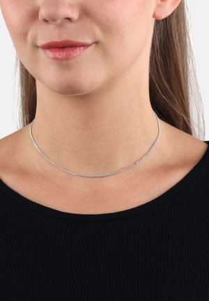 Collar de cadena de plata, textura suave, diseño plano, ajustado al rededor del cuello, usado sobre una camiseta negra.