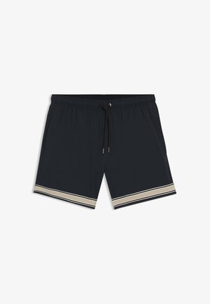 Costume da bagno nero con elastico in vita, coulisse nera, tasche laterali e doppie strisce beige-bianco lungo l'orlo delle gambe.