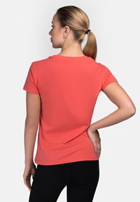 Coral short-sleeve t-shirt made of soft cotton, featuring a round neckline and a relaxed fit, seen from the back with a smooth texture.