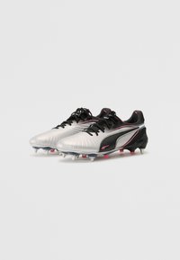 Puma football boots with a metallic silver upper, black accents, and pink detailing. Features a textured surface and multi-stud outsole.