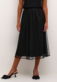 Fustă midi din tul negru cu talie elastică, design stratificat, asortată cu pantofi cu toc slingback negri, decorati cu accente de fundiță.