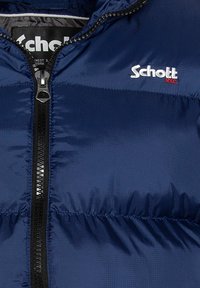 Marineblaue Pufferjacke mit gestepptem Muster, ausgestattet mit einem Frontreißverschluss und einem kleinen weißen und roten "Schott"-Logo auf der Brust.