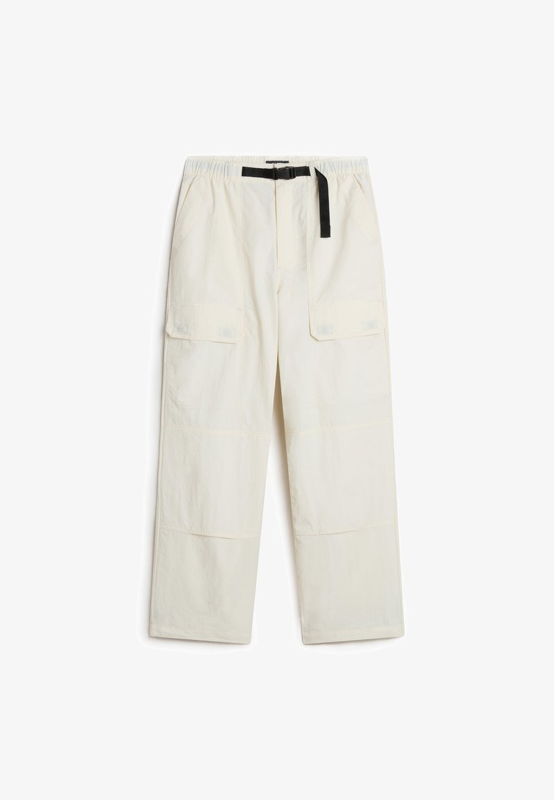 Pantalons cargo crème clair en tissu respirant, avec une taille élastiquée, une ceinture noire et plusieurs poches latérales.