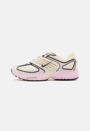 Creme- og lyserød Nike-sneaker med sorte detaljer, meshpaneler og en fuldlængde Air-sål, vist fra siden på en ensfarvet baggrund.