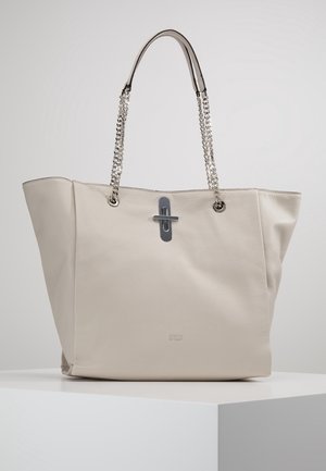 Beige læder tote taske med sølvkædehåndtag og horisontalt metalspænde på en hvid overflade mod en ensfarvet grå baggrund.