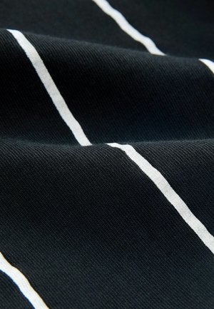 Mustmust kangas, millel on tekstureeritud pind, millel jooksevad horisontaalselt valged ja heleda beeži triibud sujuvas kudumises.