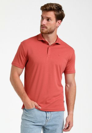 Polo de manga corta en color coral con una tapeta de tres botones. Fabricado con un tejido suave, presenta un logo sutil y un ajuste relajado.