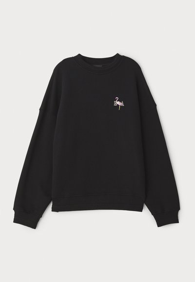 Sweatshirt preto com ombros caídos e decote redondo, apresentando um flamingo bordado e as iniciais "EA" no peito. Tecido suave.