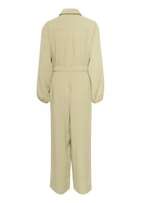 Lys beige jumpsuit med lange ærmer, kravehalsudskæring, elastisk talje og lige ben. Blødt, tekstureret stof med minimal detaljering.