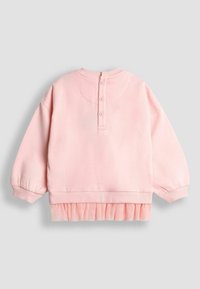 Sweatshirt roz cu mâneci lungi, guler rotund și tiv cu volane pliate. Are un sistem de închidere cu nasturi la spate și manșete cu model côtelé.
