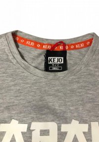 T-shirt grigia in cotone con collo rotondo, caratterizzata da una stampa bianca spessa e un'etichetta arancione a contrasto con il logo "KEJO" e i dettagli della taglia.