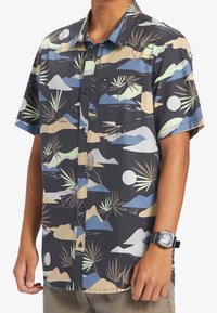 Koszula z krótkim rękawem na guziki, z ciemnym tłem i wielokolorowym wzorem gór oraz roślin; posiada kieszeń i czarne guziki.