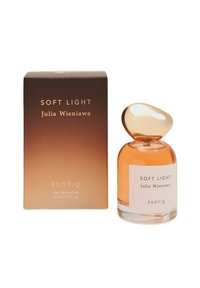 Butelka perfumu z zaokrągloną złotą nakrętką, przezroczyste ciało zawierające jasno bursztynowy płyn. Pudełko posiada brązowy gradientowy wzór ze złotym napisem.