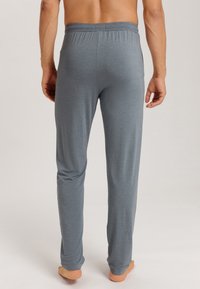 Grijze loungebroek voor heren, gemaakt van zachte stof, met een elastische tailleband en een recht model. Geen zichtbare patronen of hardware.