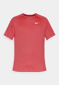 Piros sportpóló texturált mintával, rövid ujjal, kerek nyakkivágással és fehér Nike logóval a mellkason.