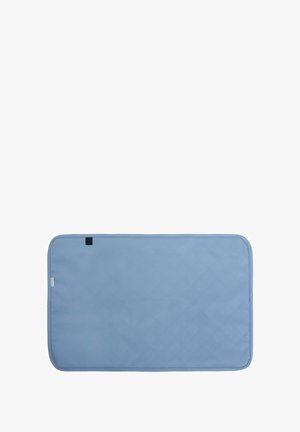 Cambiador rectangular acolchado de color azul claro con bordes redondeados y un pequeño lazo de tela negra en un lado.