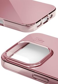 Transparent rosa telefondeksel med glatte kanter, utsparinger for knapper og kamera, samt preget logo på baksiden. Fremhever slank design.