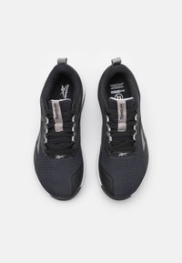 Sneaker neri in rete con una parte superiore testurizzata, suole bianche e accenti riflettenti. Presentano un colletto imbottito e un design con lacci.