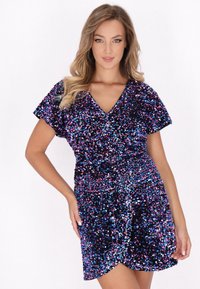 Abito viola con paillettes, maniche corte, scollatura a V e design avvolgente. Presenta paillettes multicolore che creano una superficie dinamica e testurizzata.