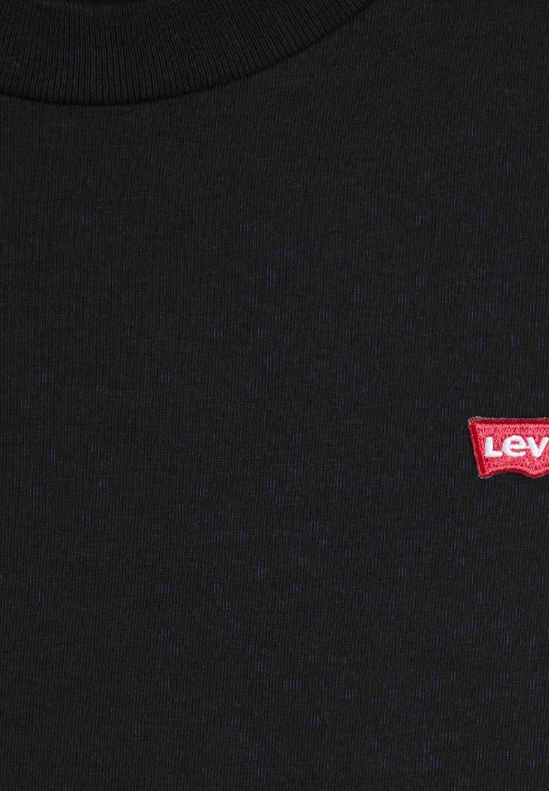 Schwarzer gerippter Rundhalsausschnittstoff mit kleinem rot-weißem Levi's-Logo auf der rechten Brustseite.